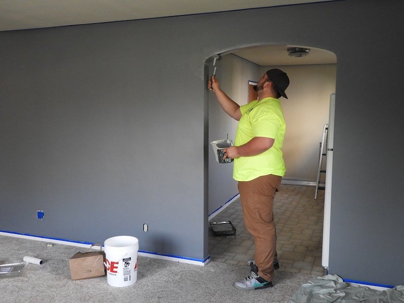 man painting inside of doorway